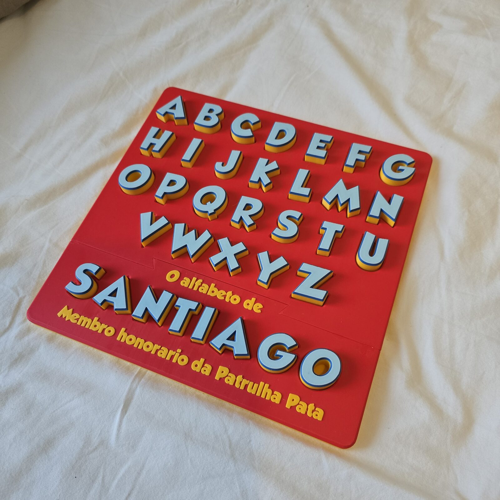 A finished alphabet board with the name Santiago spelled beneath the letters