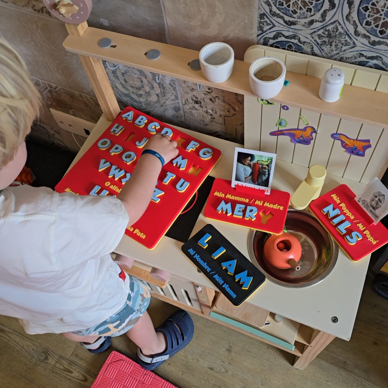 Letter boards being played with in a toy kitchen